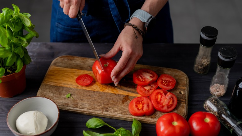 Person chopping tomatoes