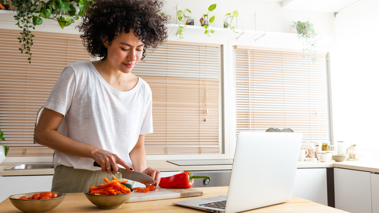 Woman cooking with recipe