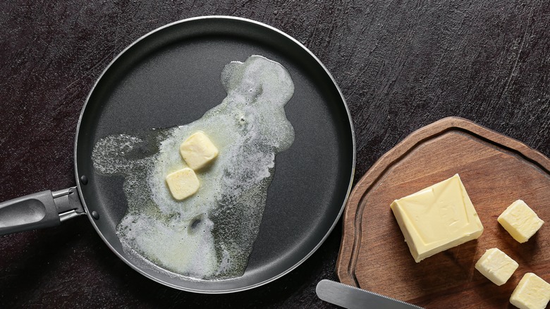 Butter in pan and on cutting board