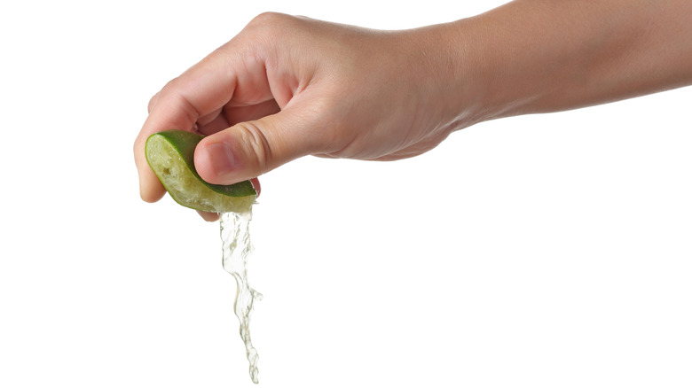 Hand squeezing juice from a lime