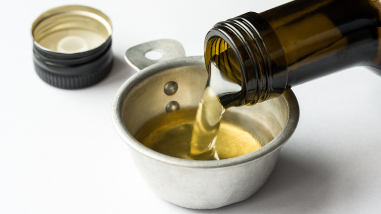 olive oil poured into measuring cup