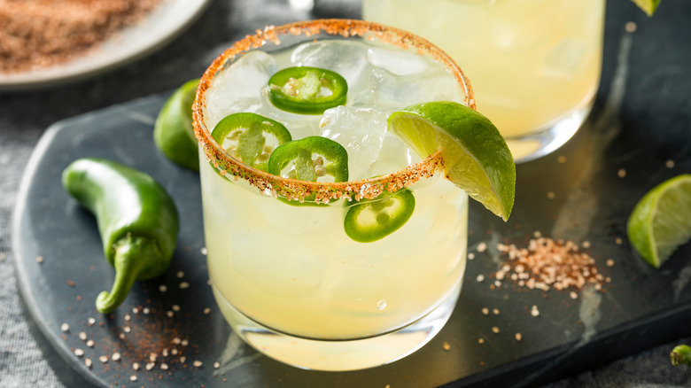 Margarita with slices of jalapeño and a lime wedge