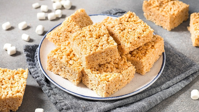 Plate of Rice Krispies treats over a grey folded cloth napkin