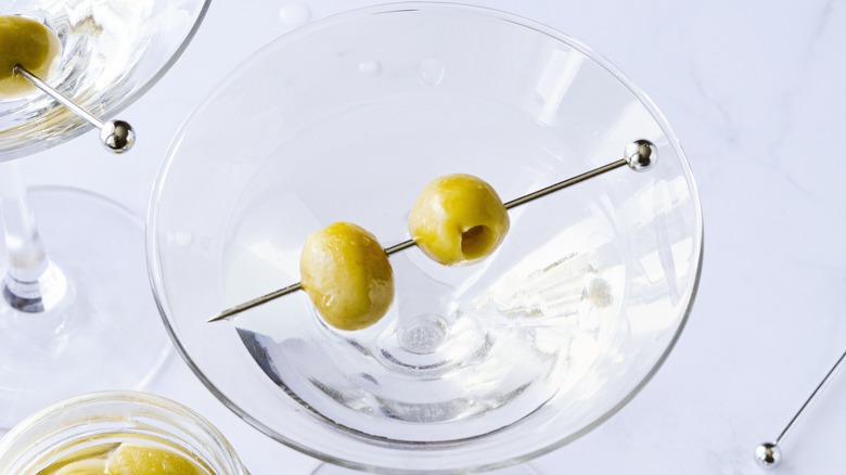 Close-up of a martini with olives from above