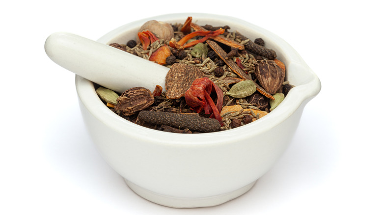 white mortar and pestle loaded with spices