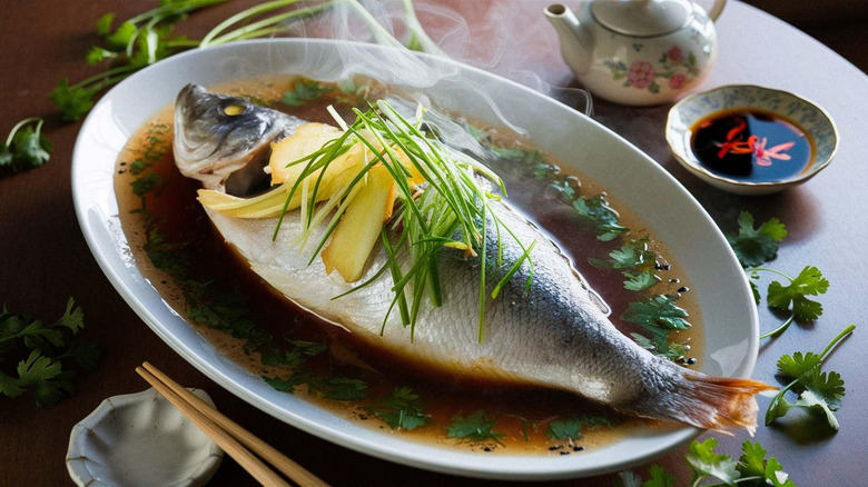 A whole cooked basa fish on a white plate