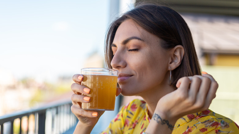 Person taking in the aroma of a glass of beer