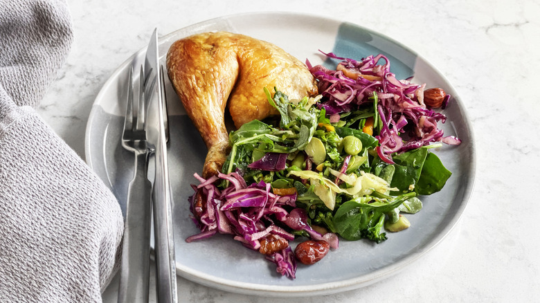 Cabbage and chicken leg on plate