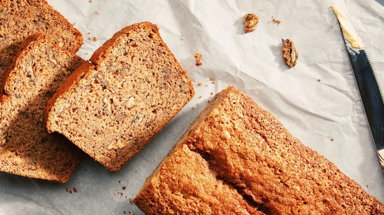 Sliced banana bread with a buttered knife