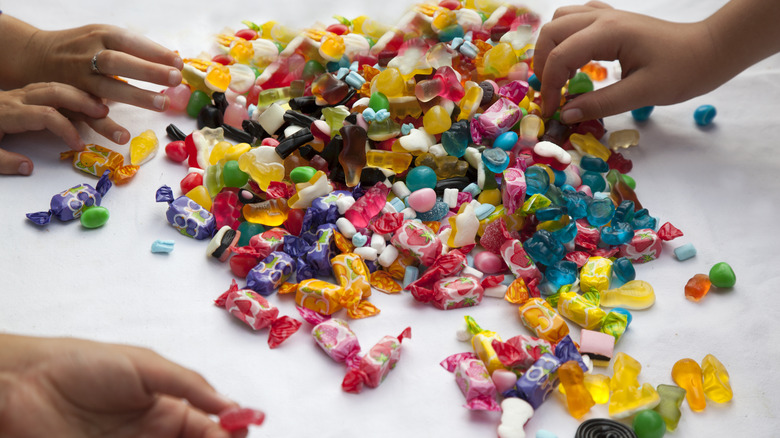 Hands sorting through pile of candy on table