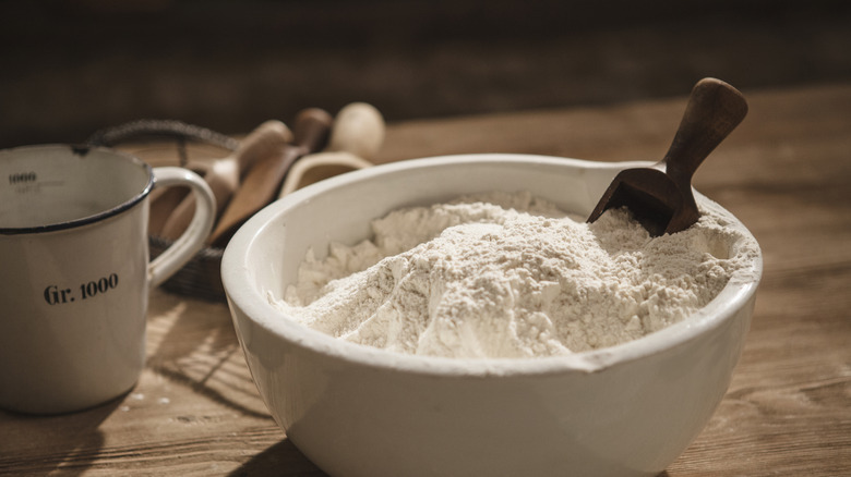 flour and a scoop in a ceramic bowl