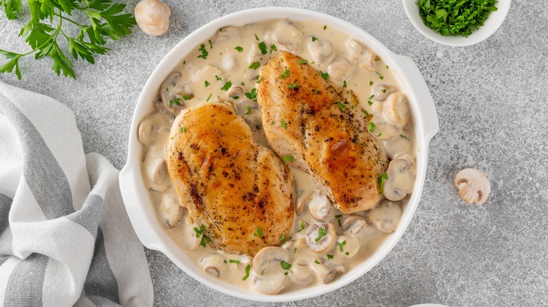 baked chcken in a dish with mushroom cream sauce