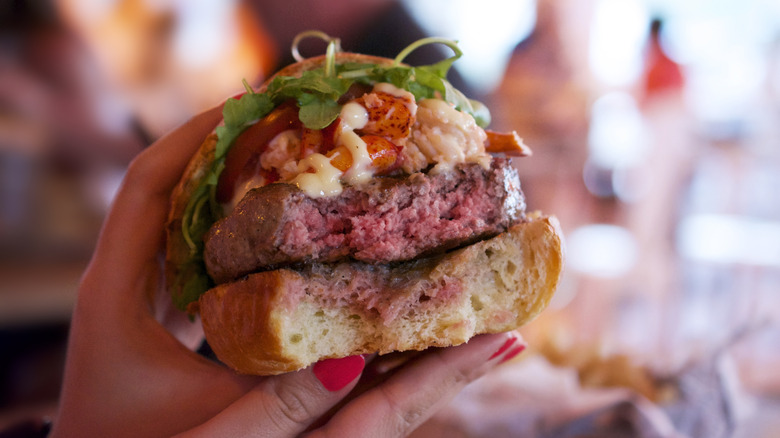 Closeup of a burger that is still pink on the inside