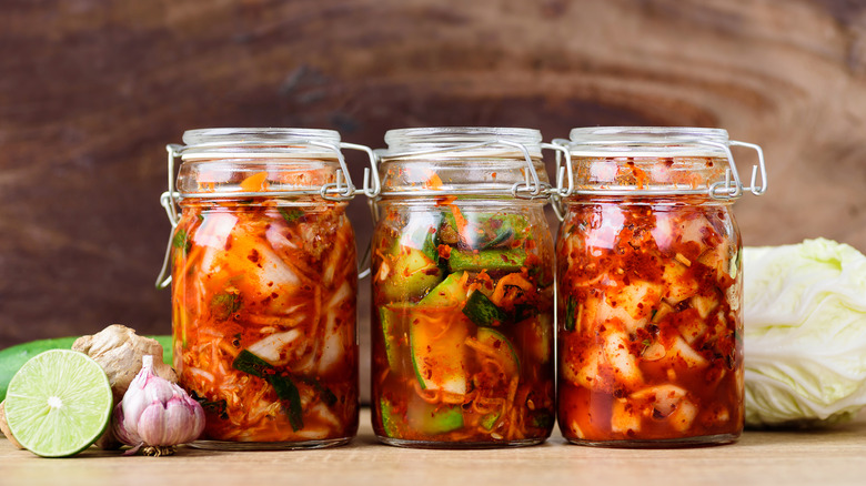 Three jars of kimchi stored in clear, airtight jars