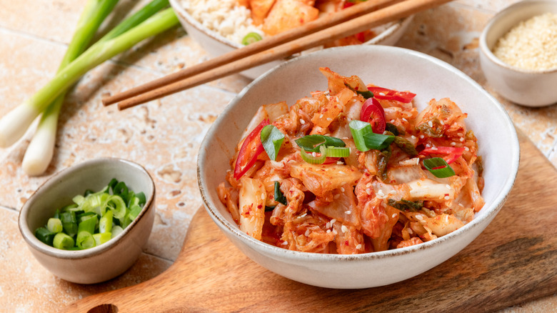 A small white bowl filled with kimchi and a set of chopsticks