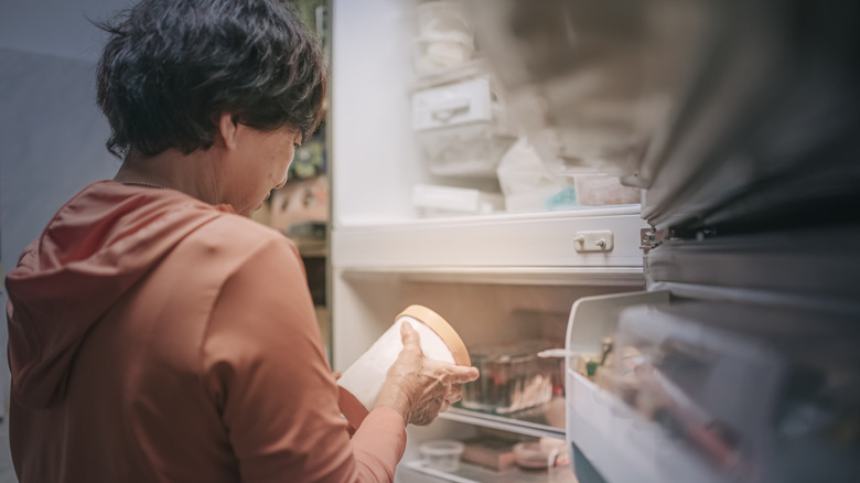 Person looking at pint of ice cream taken from freezer