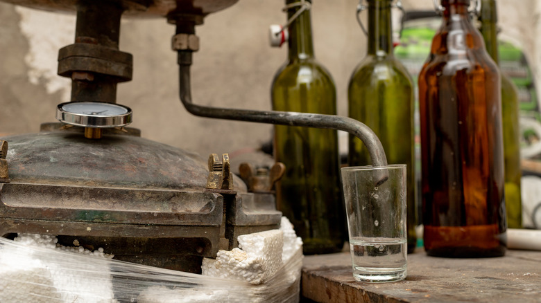 Homemade still dripping moonshine glass