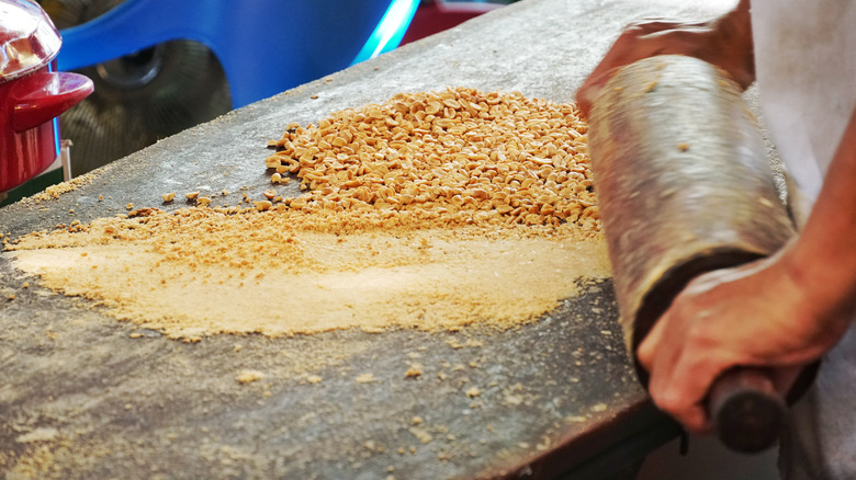 rolling crushed peanuts into powder