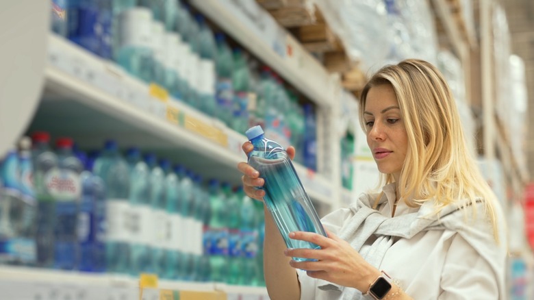 woman checking a bottle of water