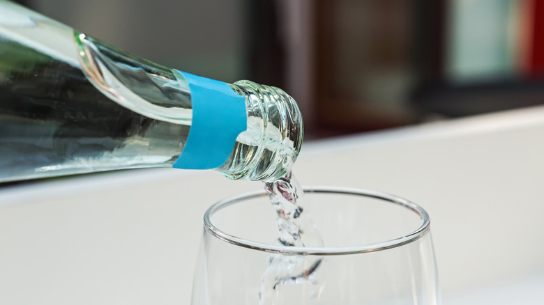 pouring sparkling water into glass