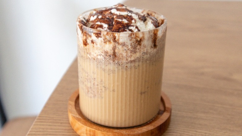 Iced almond chocolate frappe on a table topped with chocolate and whipped cream