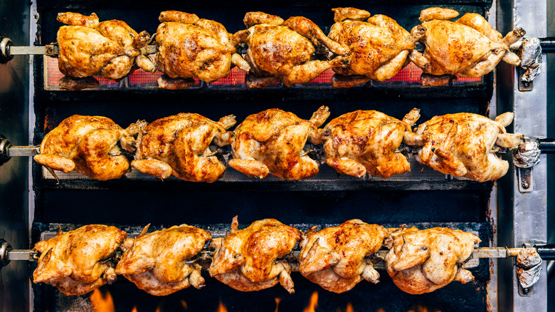 Rotisserie chickens spinning in an industrial roaster