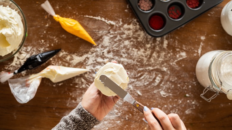 Hand frosting a cupcake