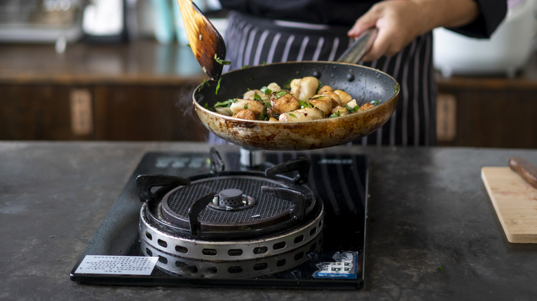 Cooking scallops in pan on stove