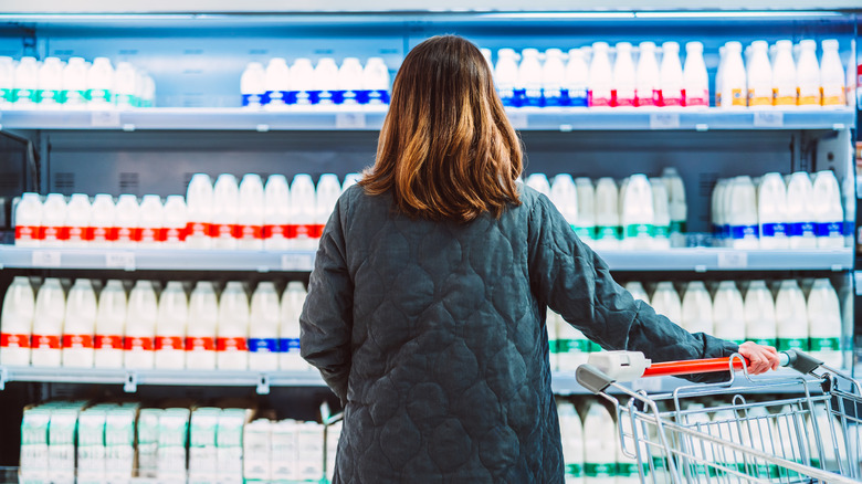 Woman choosing milk at the store