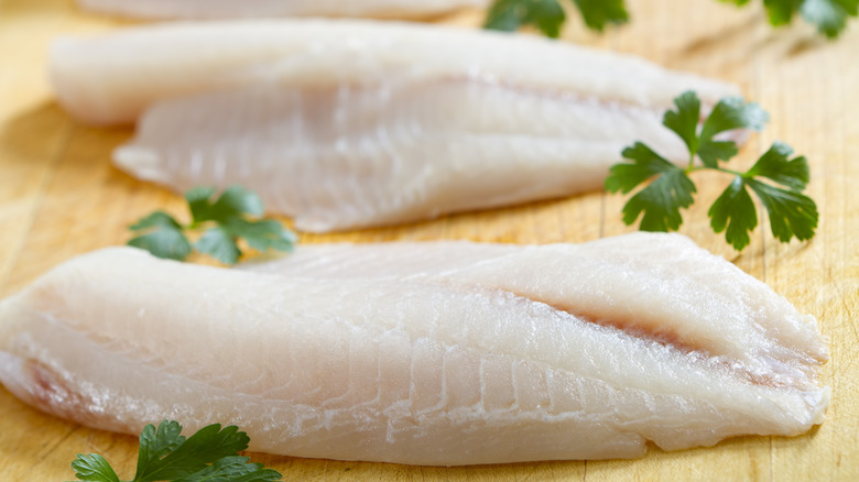 raw tilapia on cutting board