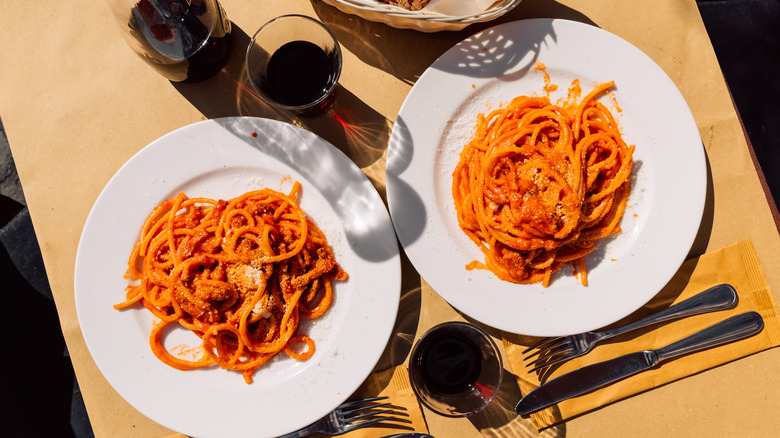 two plates of pasta with red wine