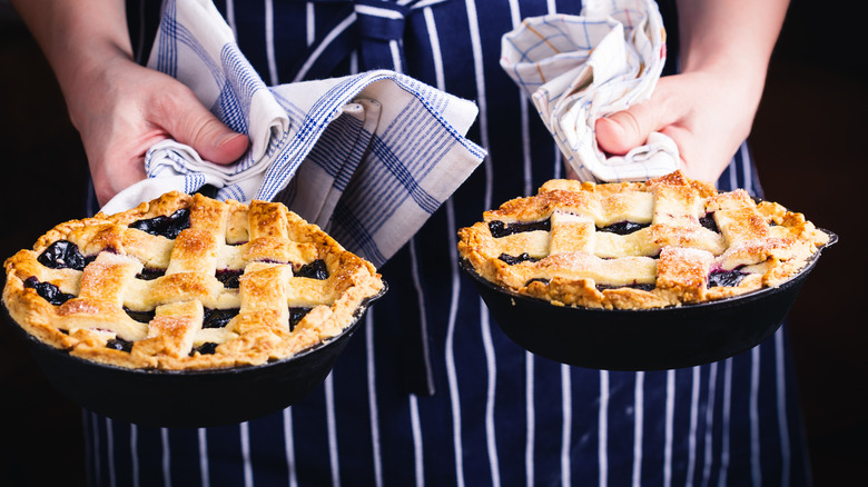 Hands holding skillet pies