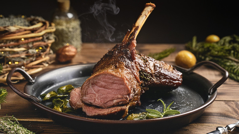 Roasted leg of lamb with herbs rests on a platter.