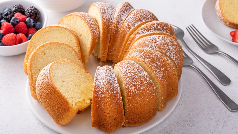 Sliced pound cake on a white plate with berries