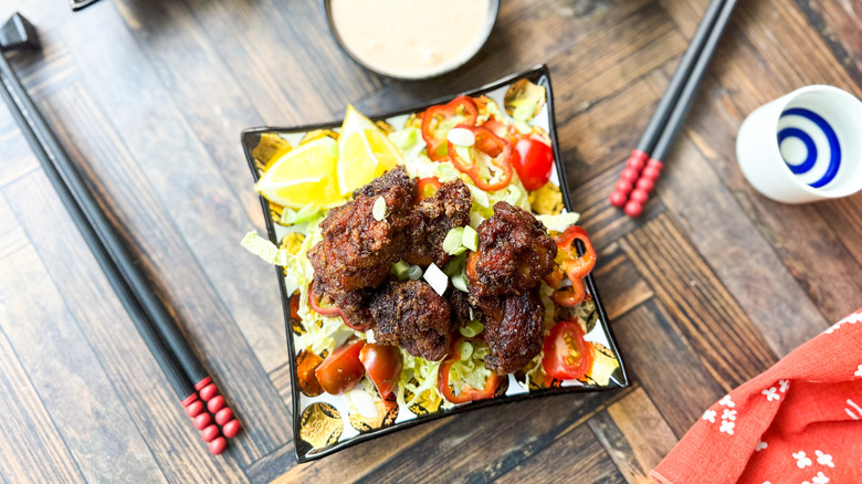 Chicken karaage on cabbage salad with spicy mayo dipping sauce and chopsticks