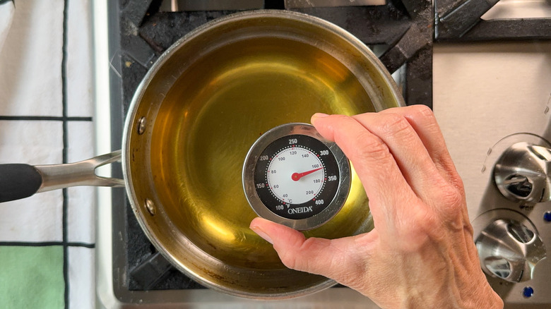 Heating avocado oil to 160 C in pot on stovetop with thermometer