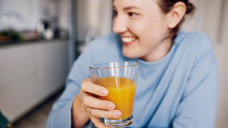 person holding a glass of orange juice