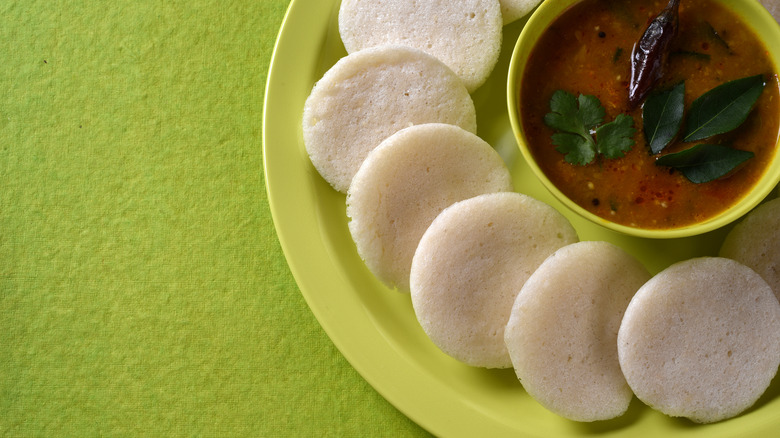 idli with sambar on green plate