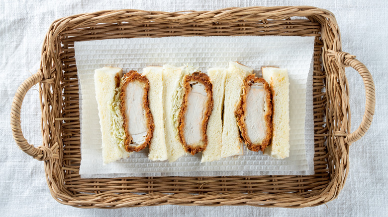 Katsu sando halves on paper towel in a wicker tray