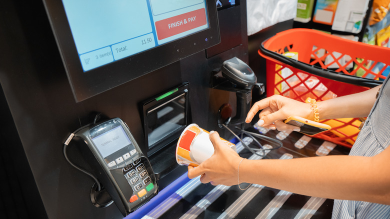 Person using a self-checkout machine.