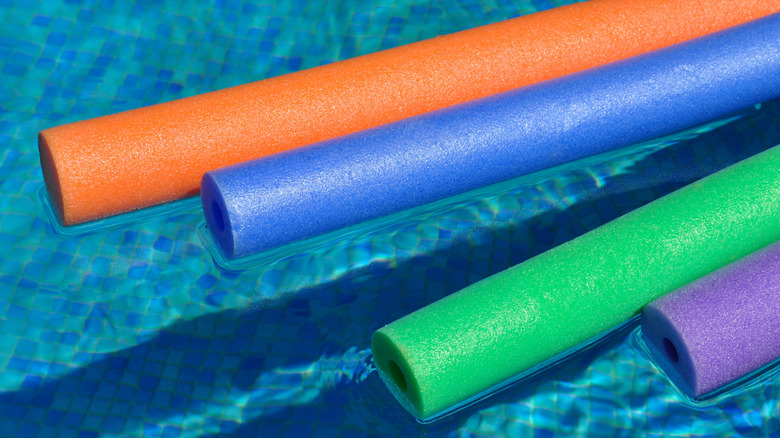 Colorful pool noodles floating on water