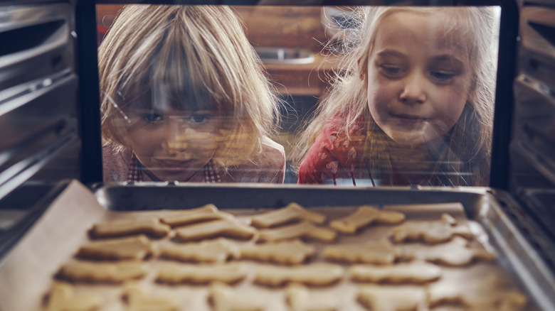 Girls looking at cookies baking