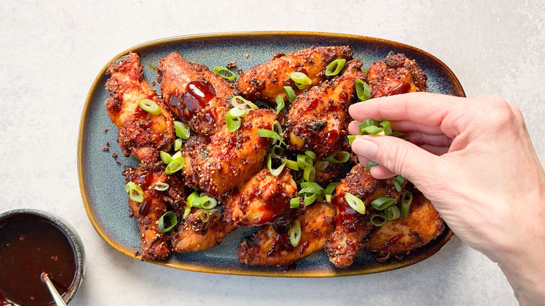 Korean dry-rubbed chicken wings on serving platter with scallion garnish