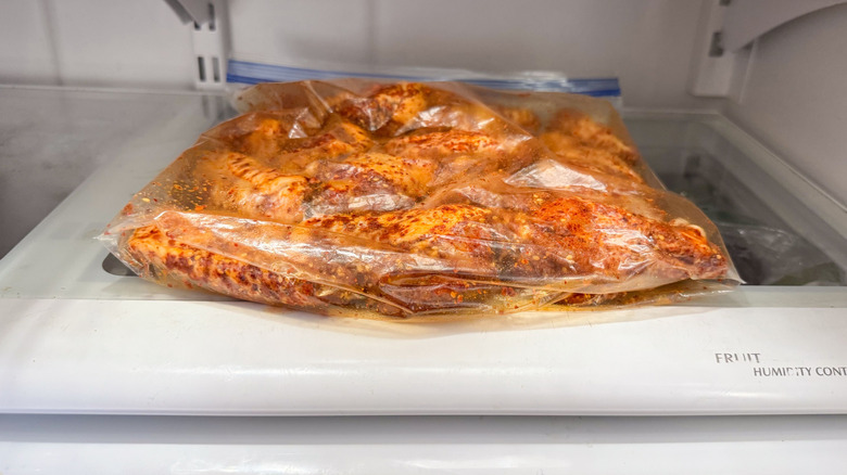 Chicken wings with dry rub in ziplock bag in refrigerator