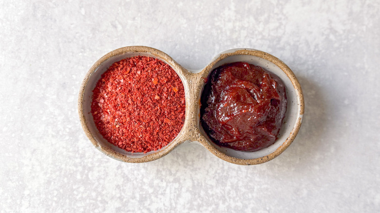 Gochugaru chili flakes and gochujang chili paste in serving dish