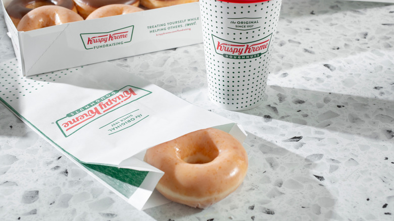 Krispy Kreme donuts and coffee sitting on a countertop