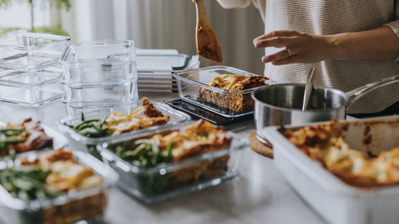 Person putting meal prep food into glass storage containers