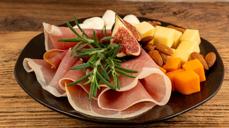 Sliced serrano ham with figs, almonds and cheese