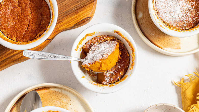 Spoon with carrot souffle inside a ramekin