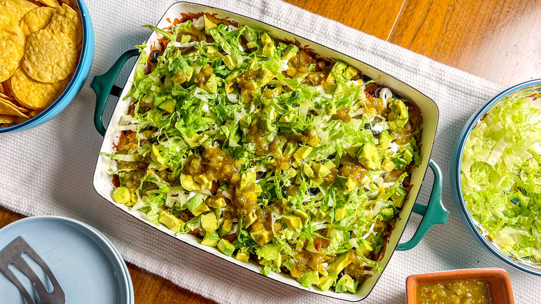 Loaded beef taco casserole in baking dish with chips and shredded lettuce